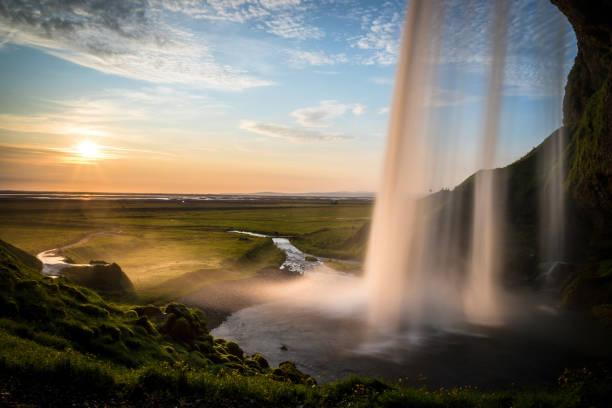 istock Magical view of a sunset over a vast field with a waterfall 1441583772
