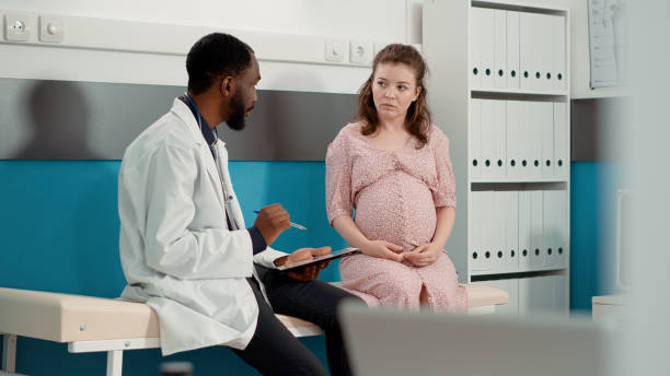 istock Male physician having conversation with future mother in cabinet 1441583919
