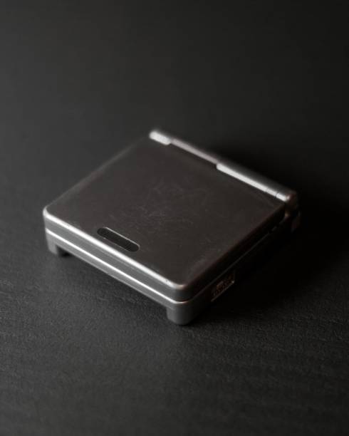 istock Black Gameboy advance on the table isolated with black background 1441584057