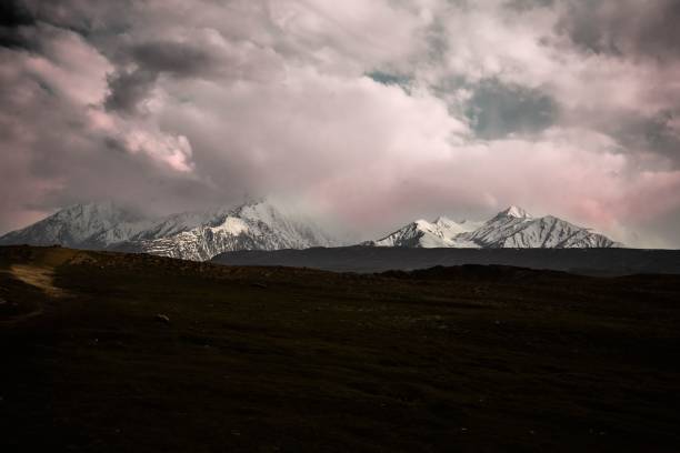 istock Panoramic view of the snowy mountains and pink clouds 1441584111