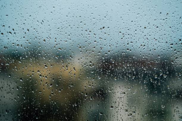istock Rain drops on the window glass with blurry background. 1441584305