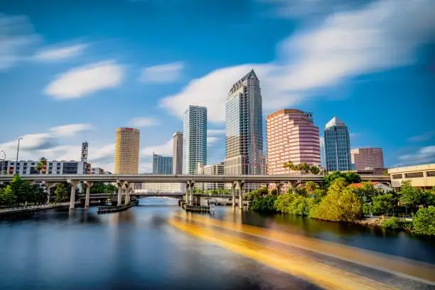 The skyline of downtown Tampa on the Hillsborough river under a blue sky