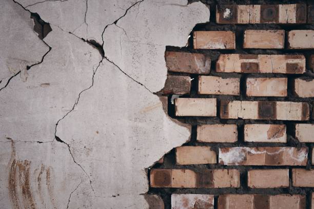 istock Wall with a half of bricks and other half of cracked cement 1441584650