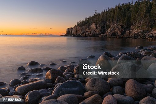 istock Beautiful scene of Boulder Beach in Acadia National Park, Maine with green hills and an orange sky 1441584860