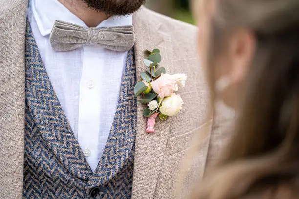 A closeup of the groom's boutonniere during his wedding ceremony