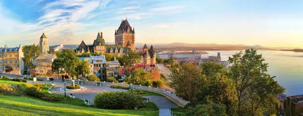 A panoramic view of Chateau Frontenac surrounded by greenery in Old Quebec, Canada at sunrise