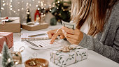 Girl counting US Dollar bills, using calculator, and writing expenses. Woman doing budget, estimating money balance for shopping spree. Female accountant paying taxes. Girl counting Christmas gifts
