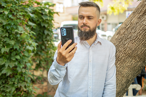 Handsome man talking his mobile phone outdoors