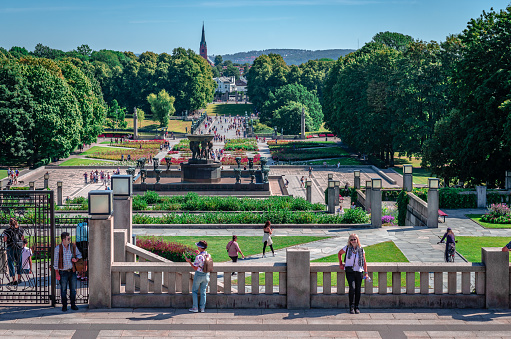 Oslo, Norway - August 13 2022: People enjoy a sunny day in Frogner Park, with the Vigeland installation seen in the centre.