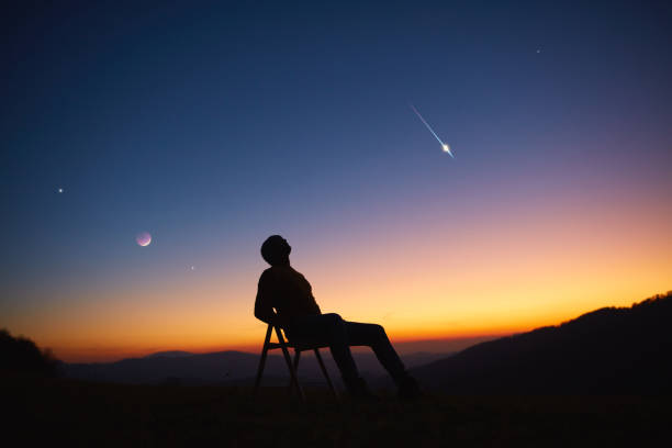 Man looking at the night sky, stars, planets, Moon and shooting stars. Man looking at the night sky, stars, planets, Moon and shooting stars. meteor shower stock pictures, royalty-free photos & images