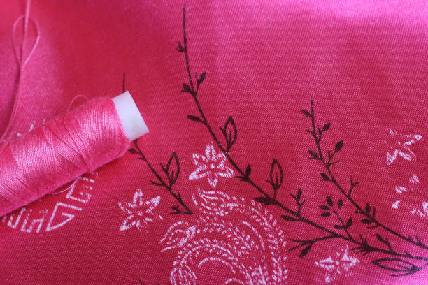 Spool of Pink Thread and Thimble on Vintage Pink Satin