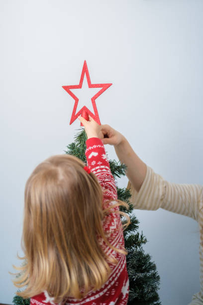 istock Mother and daughter decorating the Christmas tree 1441604559