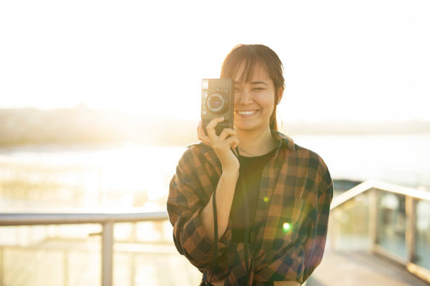 Attractive tourist with a camera. Beautiful woman with camera taking photos of beautiful location.