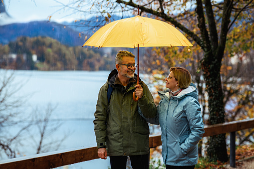 Mature couple enjoying a rainy day on Lake Bled in SLovenia