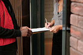 Hands of young female customer signing delivery document