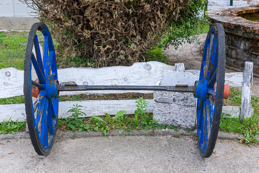An antique wooden wagon wheel in a field