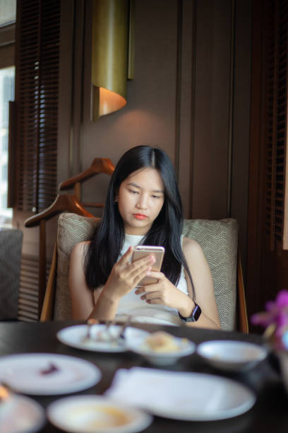 istock woman eating breakfast and using mobile phone 1441609954