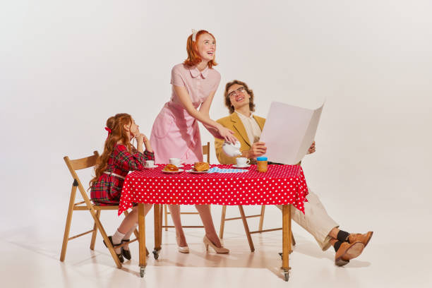 feliz manhã. família alegre, mãe, pai e filha tomando café da manhã sobre fundo cinza - 1960s style image created 1960s retro revival family - fotografias e filmes do acervo