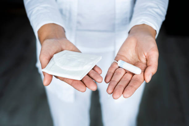 el ginecólogo sostiene un tampón en sus manos y una almohadilla ofrece una opción - menstruation tampon gynecological examination sex fotografías e imágenes de stock