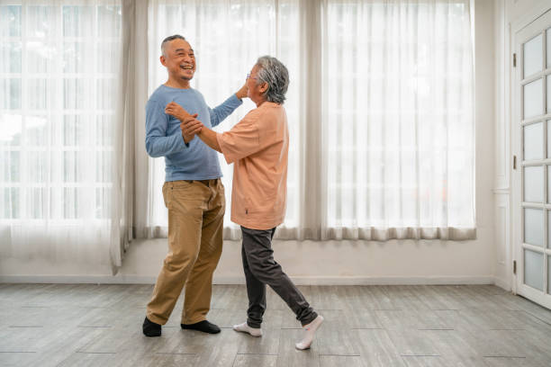 istock Asian senior couple dancing at home while holding hands with happy expression and smiling faces convey satisfaction at the beautiful time 1441616031