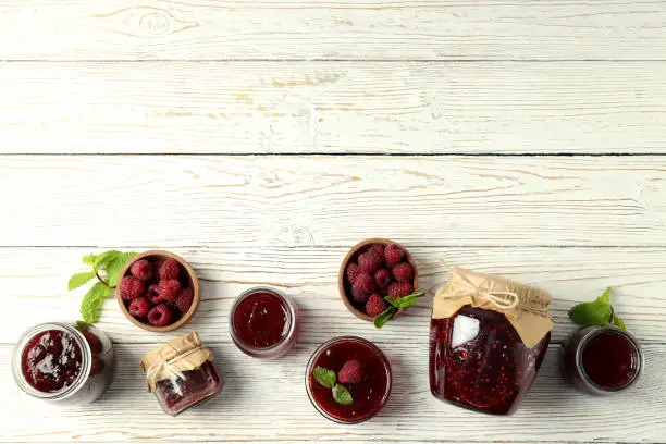 Flat lay composition with raspberry jam on wooden background