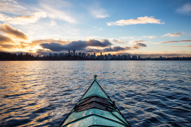 kajakfahren durch vancouver mit downtown skyline im hintergrund - vancouver skyline city urban scene stock-fotos und bilder