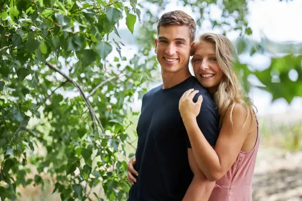 a portrait of a young couple smiling and looking at the camera
