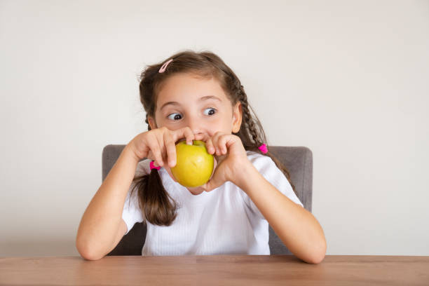 istock Cute girl eating apple 1441620625