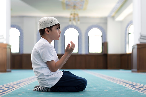 The boy who goes to the Quran course prays in the mosque.