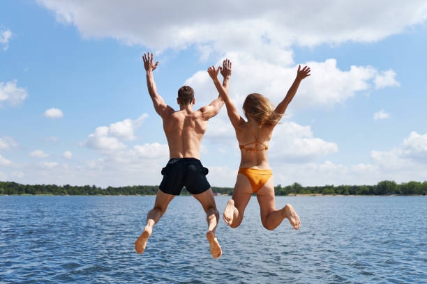 istock A young couple jumps off a pier into a lake 1441622744