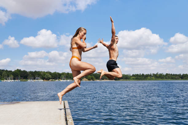 istock A young couple jumps off a pier into a lake 1441622773