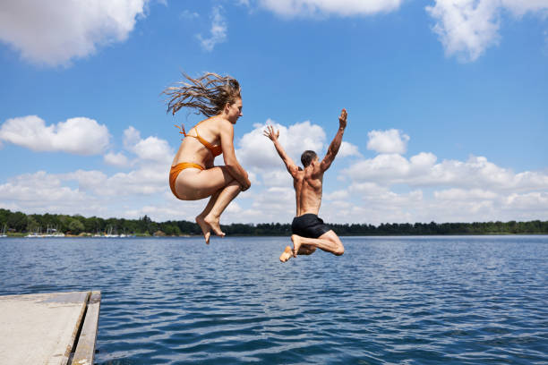 istock A young couple jumps off a pier into a lake 1441622893
