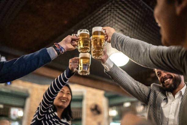 istock Coworkers toasting a beer at a bar 1441623379