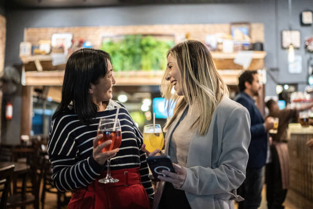 istock Coworkers talking and drinking cocktails at a bar 1441624837