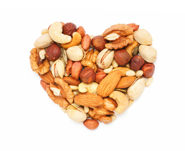 istock Heart shaped nuts and seeds isolated on white background close-up 1441631173