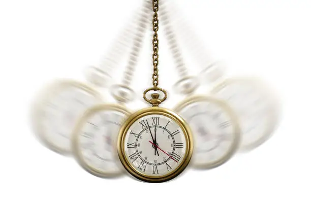 Photo of Gold Pocket watch swinging hypnotically from chain. White background. Hypnotism concept