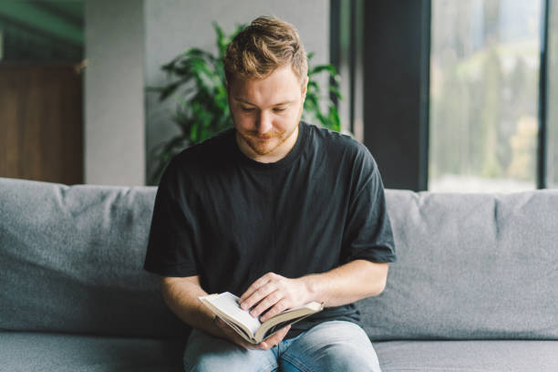 istock Beauty young man is reading a book at home. 1441635213