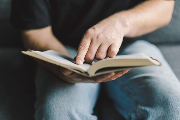 istock Christian man holds holy bible in hands. 1441635232