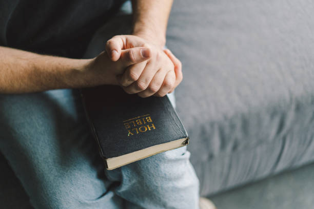 istock Christian man holds holy bible in hands. 1441635252