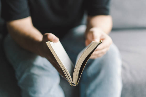 istock Christian man holds holy bible in hands. 1441635297