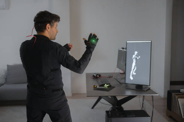 A Caucasian guy is creating a 3d animation by using a mock-up smart suit.