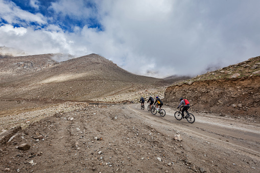 Kardung La Pass, India - September 5, 2011: Bicycle tourists in Himalayas asceinding to Khardung La the highest motorable pass in the world. Himalayan bycicle tourism is gaining popularity all over the world