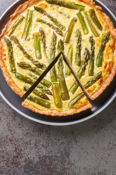 istock Baked pie egg custard is studded with fresh asparagus a perfect spring side dish or vegetarian main dish close-up in a plate. Vertical top view 1441642771