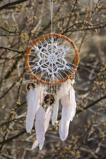 istock Handmade dream catcher with white doily on background of branches 1441643565
