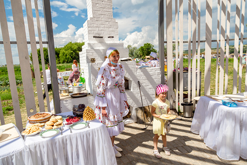 Little boy and girl in Slavic national clothes on a wooden background. Belarusian or Ukrainian children in embroidered shirts.