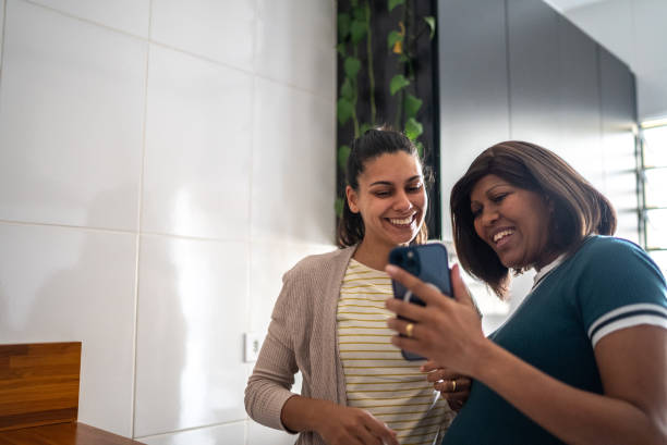 istock Pregnant lesbian couple using mobile phone at home 1441645102