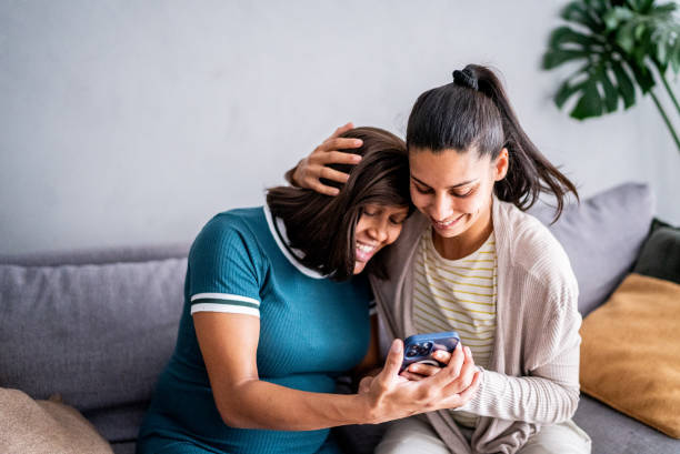 istock Pregnant lesbian couple using mobile phone at home 1441645281