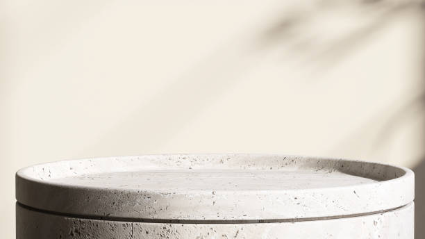 istock Minimal white granite rock podium table with dappled sunlight and leaf shadow on cream wall background 1441645951