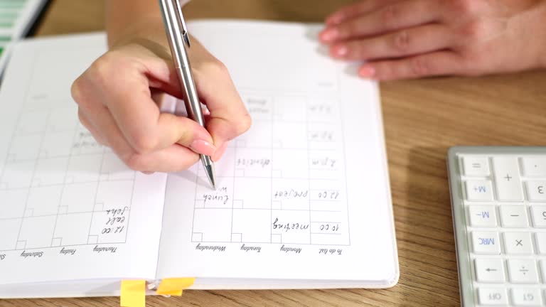 Woman writes notes, to-do list and diary for budget planning and meetings