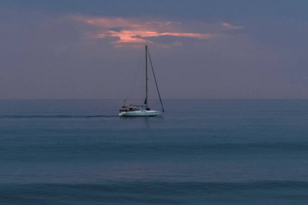 Little sailboat sailing on the Atlantic ocean at sunset, Maspalomas, Gran Canary, Canary Islands, Spain